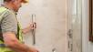 Senior home safety: contractor installing a shower grip for elderly safety.